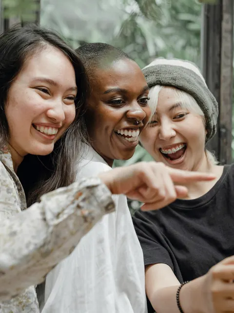 Três amigas rindo juntas